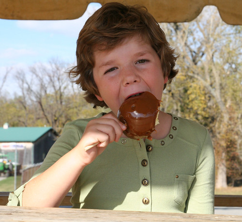 Grace Wiles, daughter of Megan Wiles, VP and president-elect of the Alliance, enjoys a crisp hand- dipped caramel apple from The Apple Store.