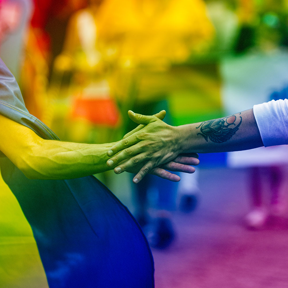 Pride rainbow flag and two arms locking together