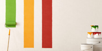 Paint brush with paint on a wall of a home