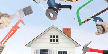 Hands holding tools surrounding a home