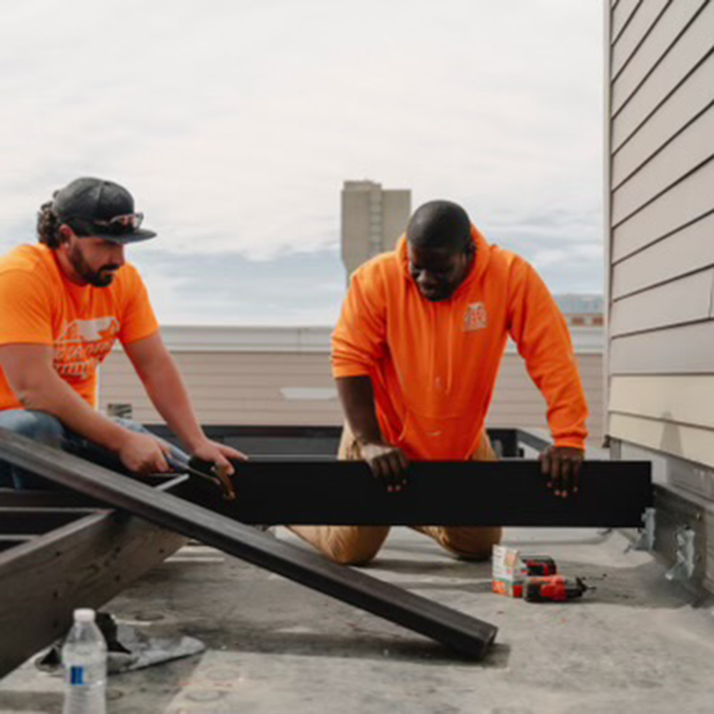 Two workmen on an Indianapolis rooftop 