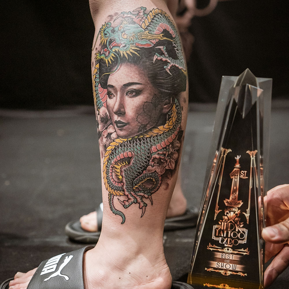 Intricate calf tattoo with award trophy from 2023
