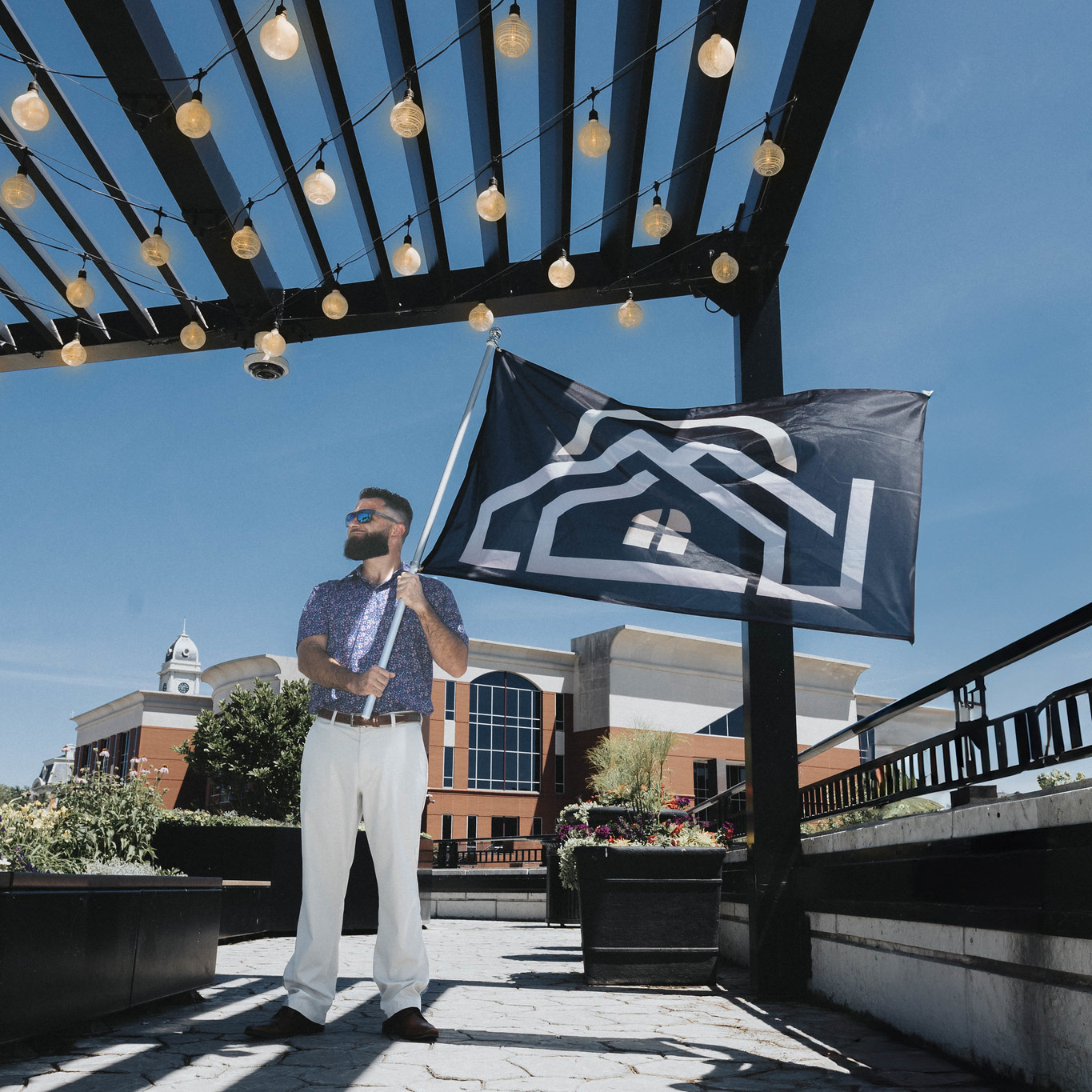 Man holding branded flag under portico