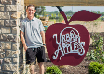 Man standing in front of Urban Apples sign