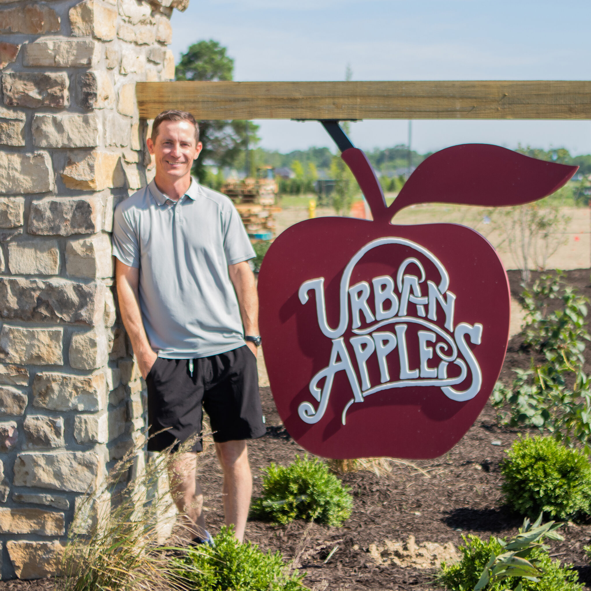 Man standing in front of Urban Apples sign