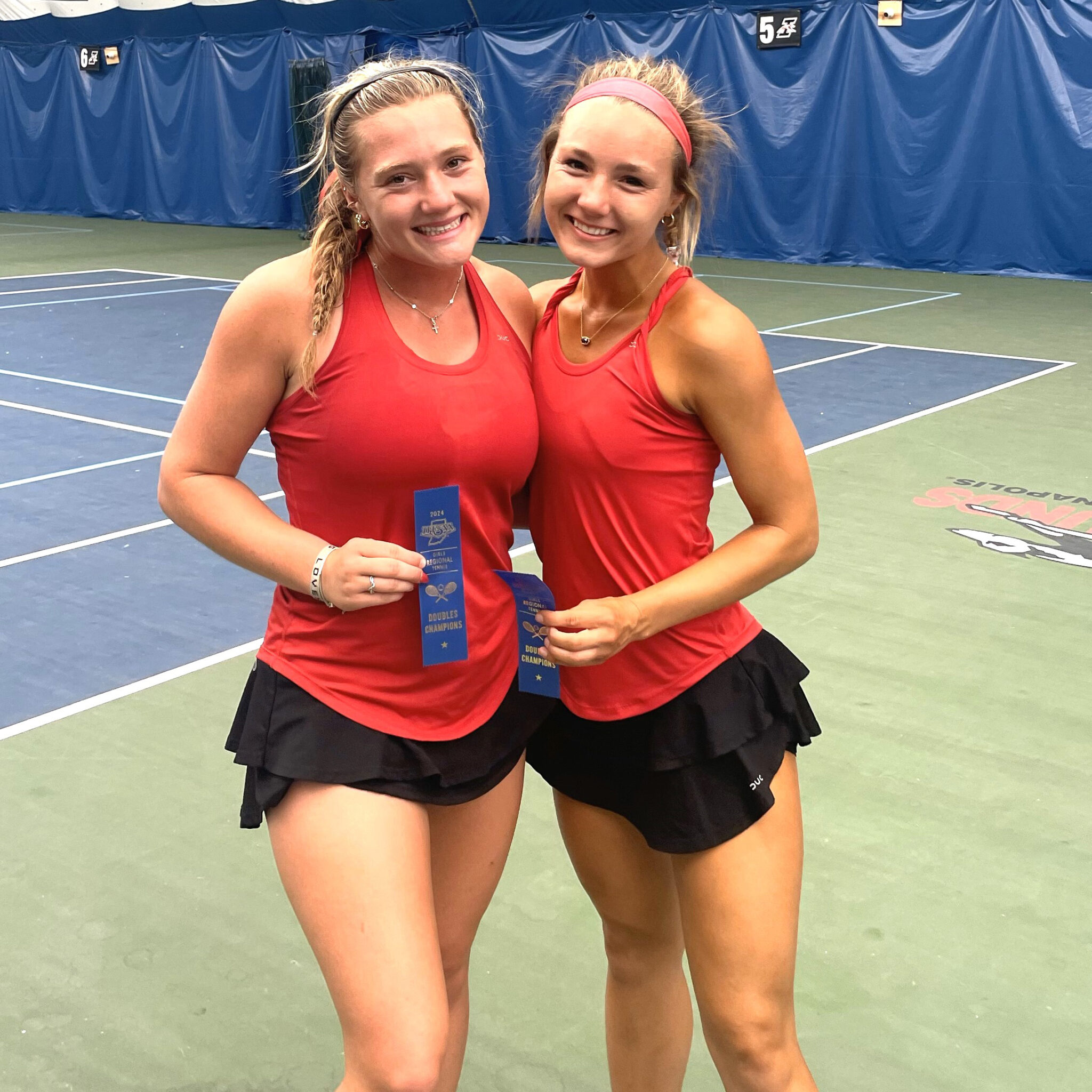 Two tennis players holding ribbons