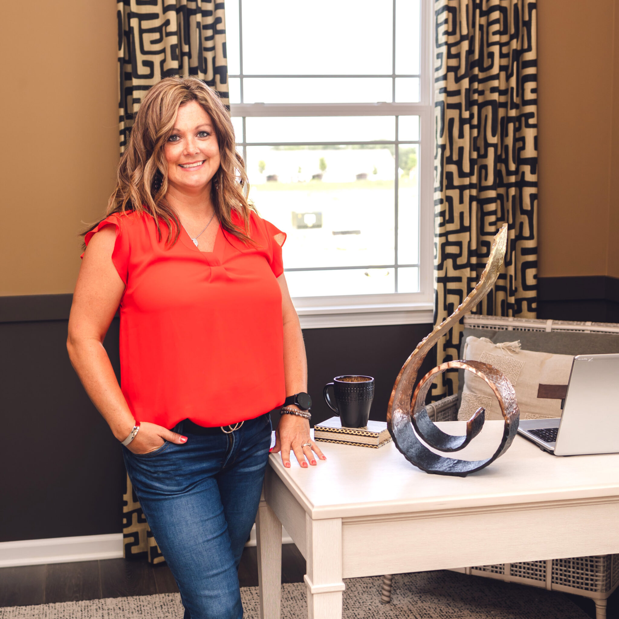 Woman standing next to desk with a swirlie statue on the desk