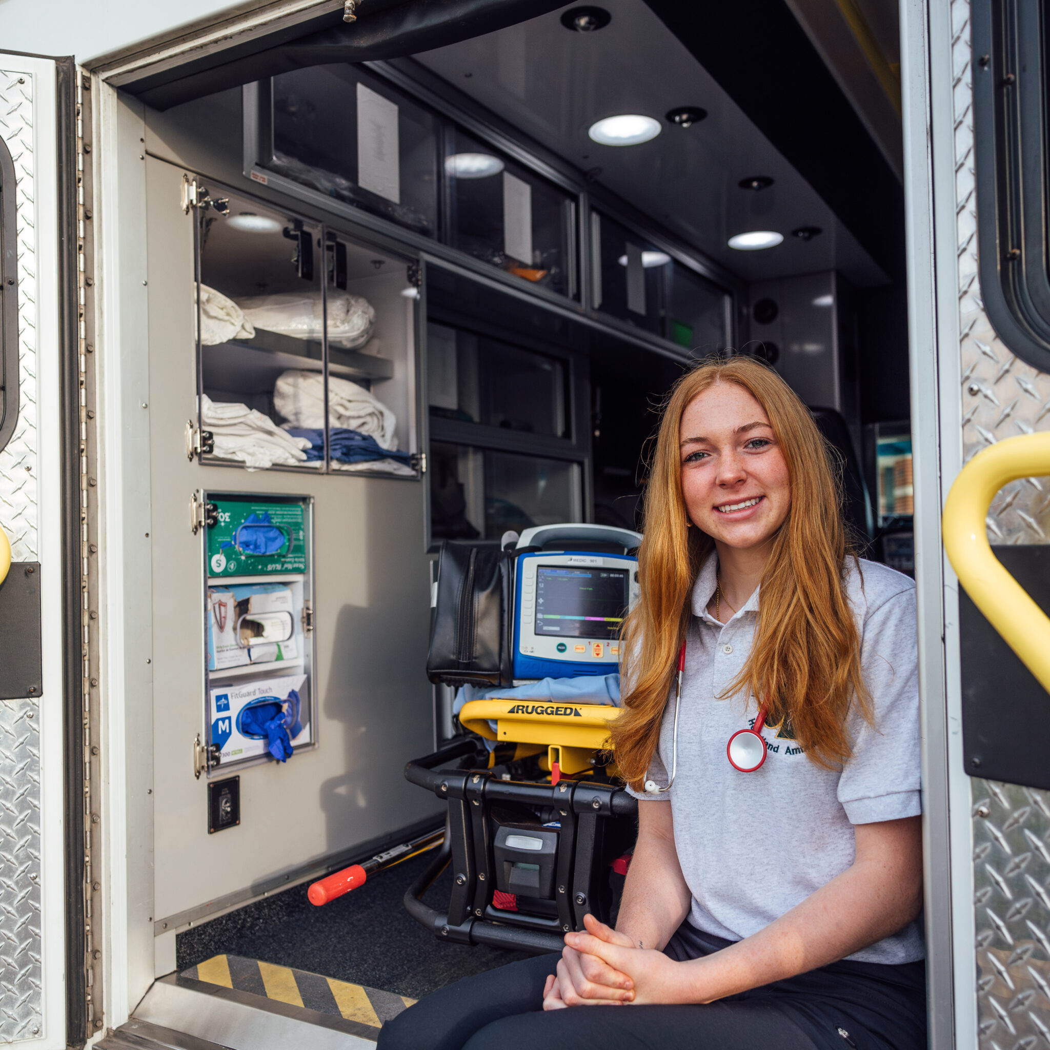 Teenager sitting on the back of an EMS truck