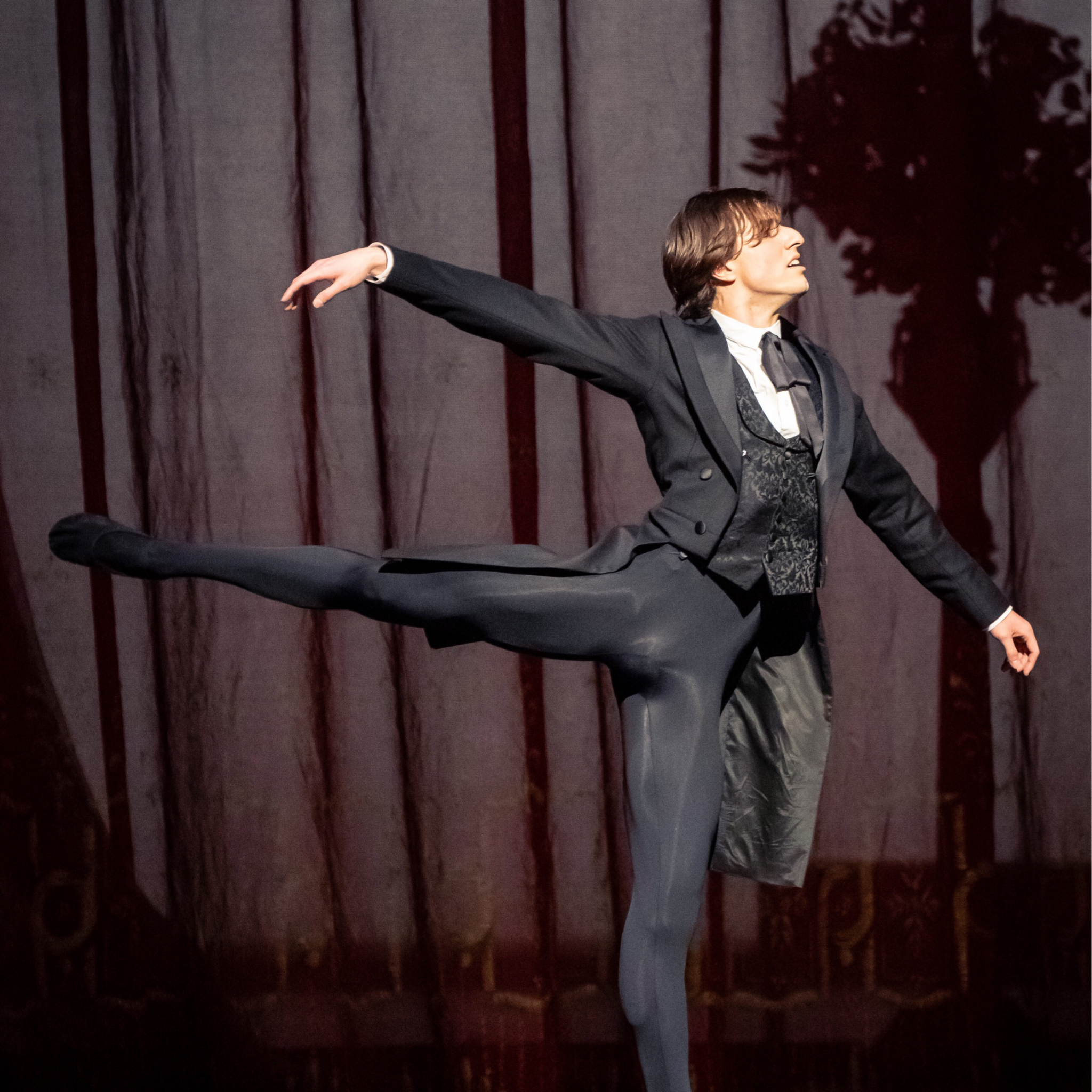 Male ballet dancer dressed in black on a stage