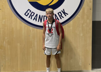 Teenage boy in front of Indiana Pacers logo