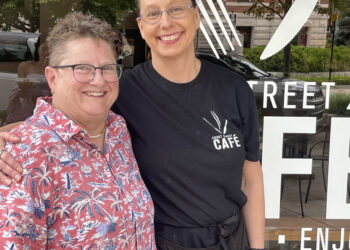 Two women standing in front of a window