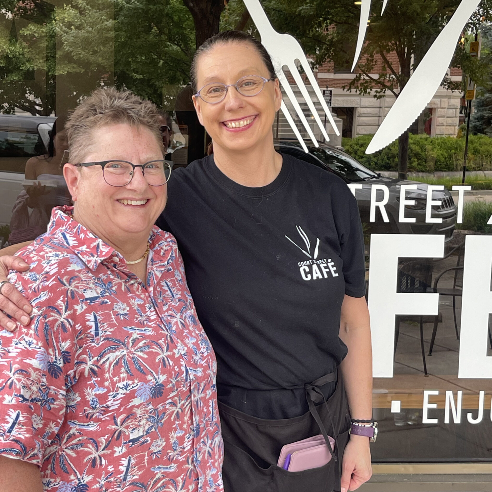 Two women standing in front of a window