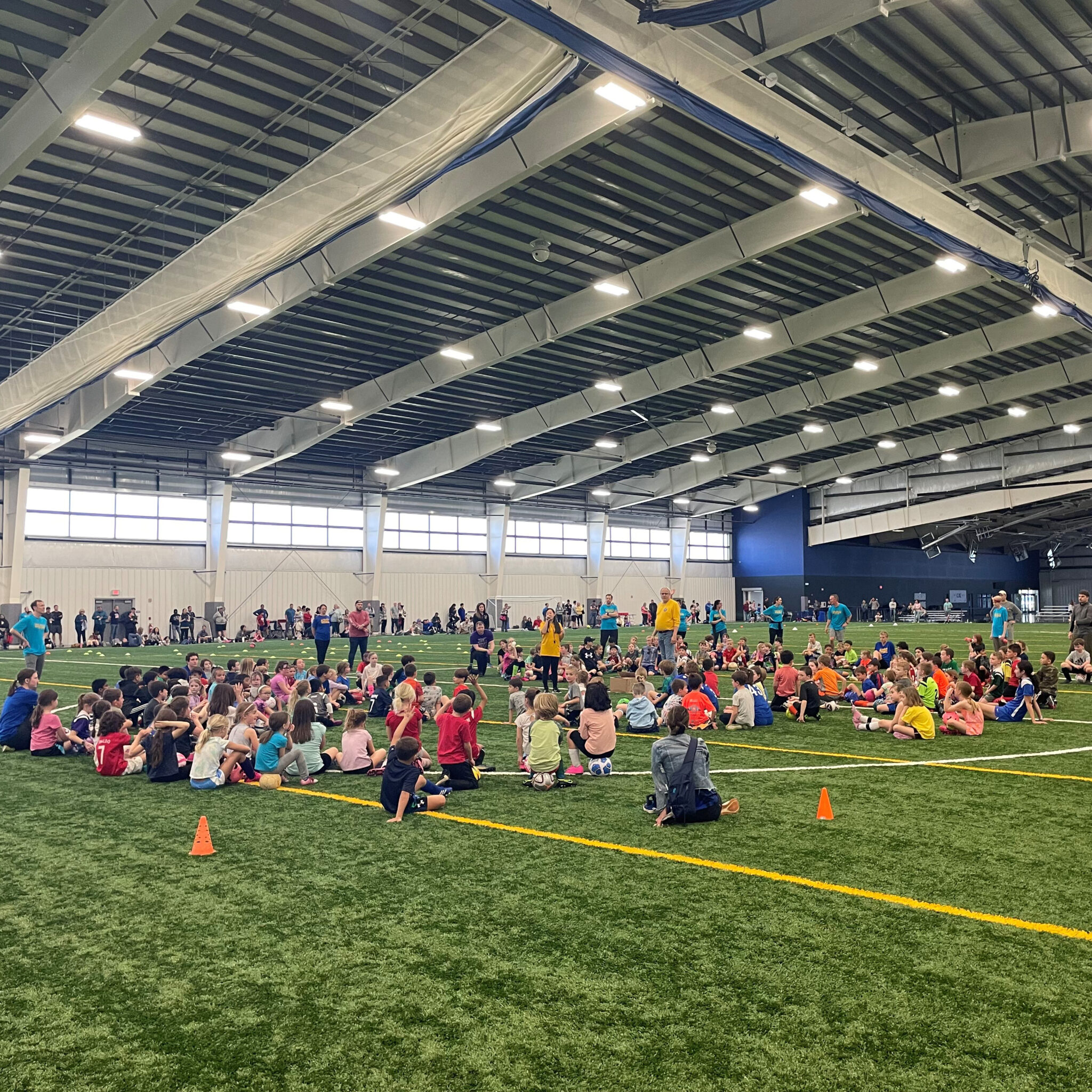 Elementary school students sitting on a football field