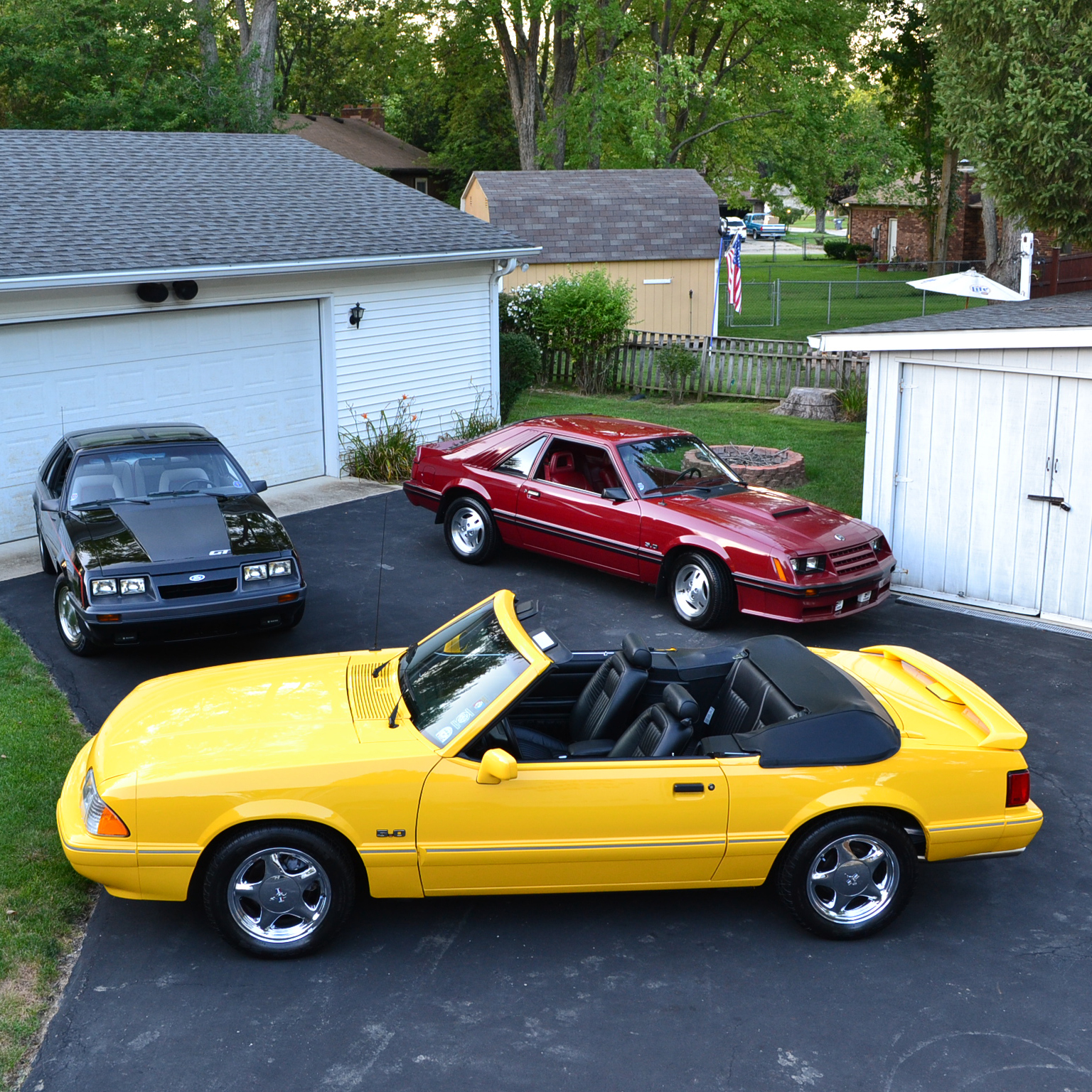 Yellow Mustang and other red vintage car