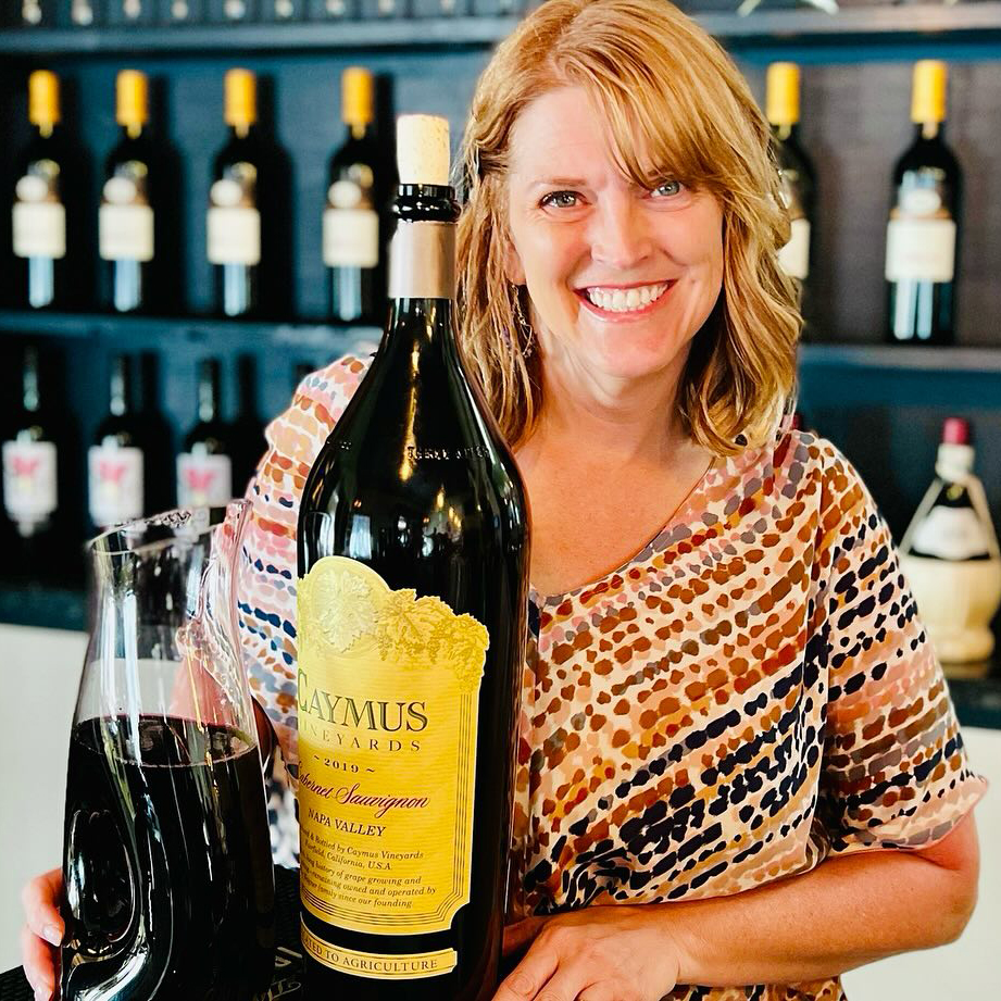 Lady holding a magnum of Caymus wine