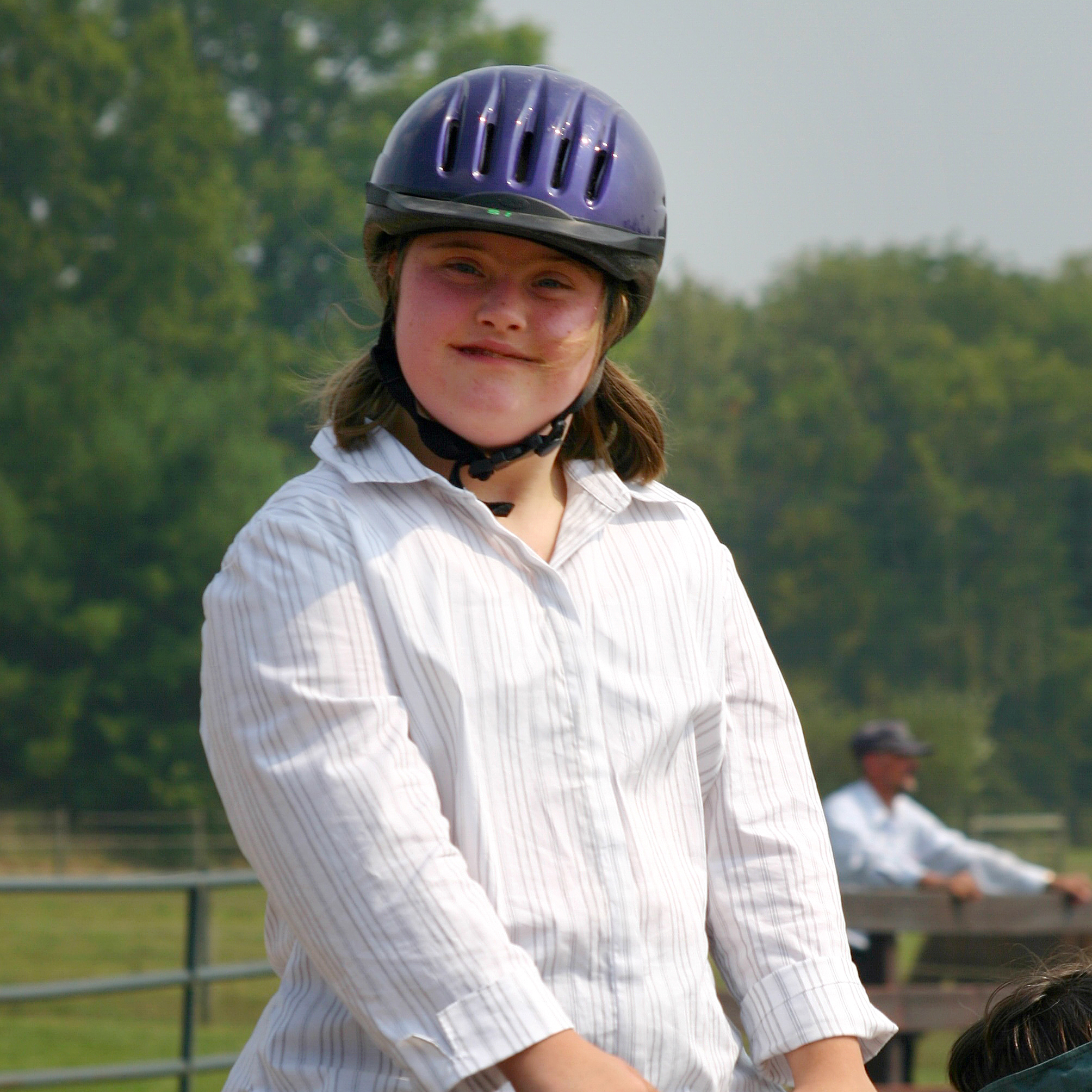 Athlete riding a horse with a purple helmet