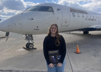 Teenager in front of a plane