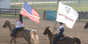Flags flying by horseback riders at the Hendricks County Fairgrounds