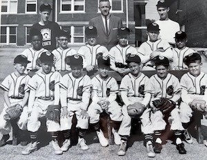A nostalgic black-and-white photo of a 1950s-era youth baseball team posing together in uniform