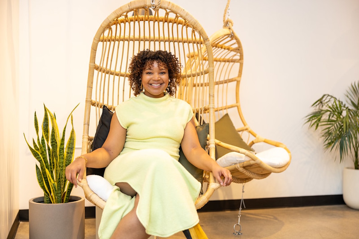 Owner of Pure Green Fishers Chasten Harmon sitting in a hanging chair
