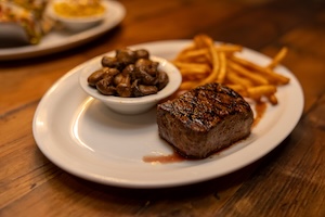 Steak with a side of mushrooms and fries
