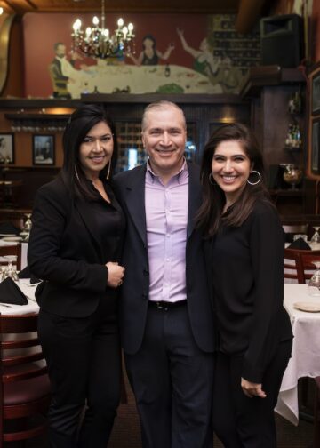 2 women and a man standing in a restaurant