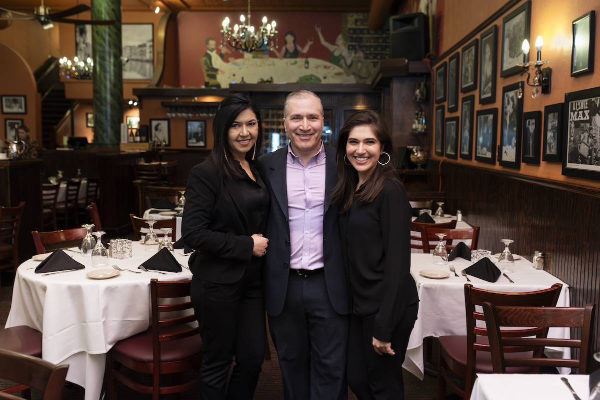 2 women and a man standing in a restaurant