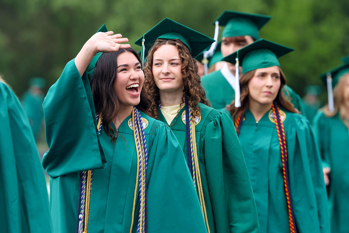 Zionsville High School graduates in green cap and gowns.
