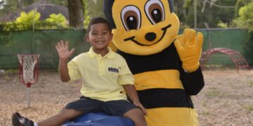 Kid City mascot with a child at the park