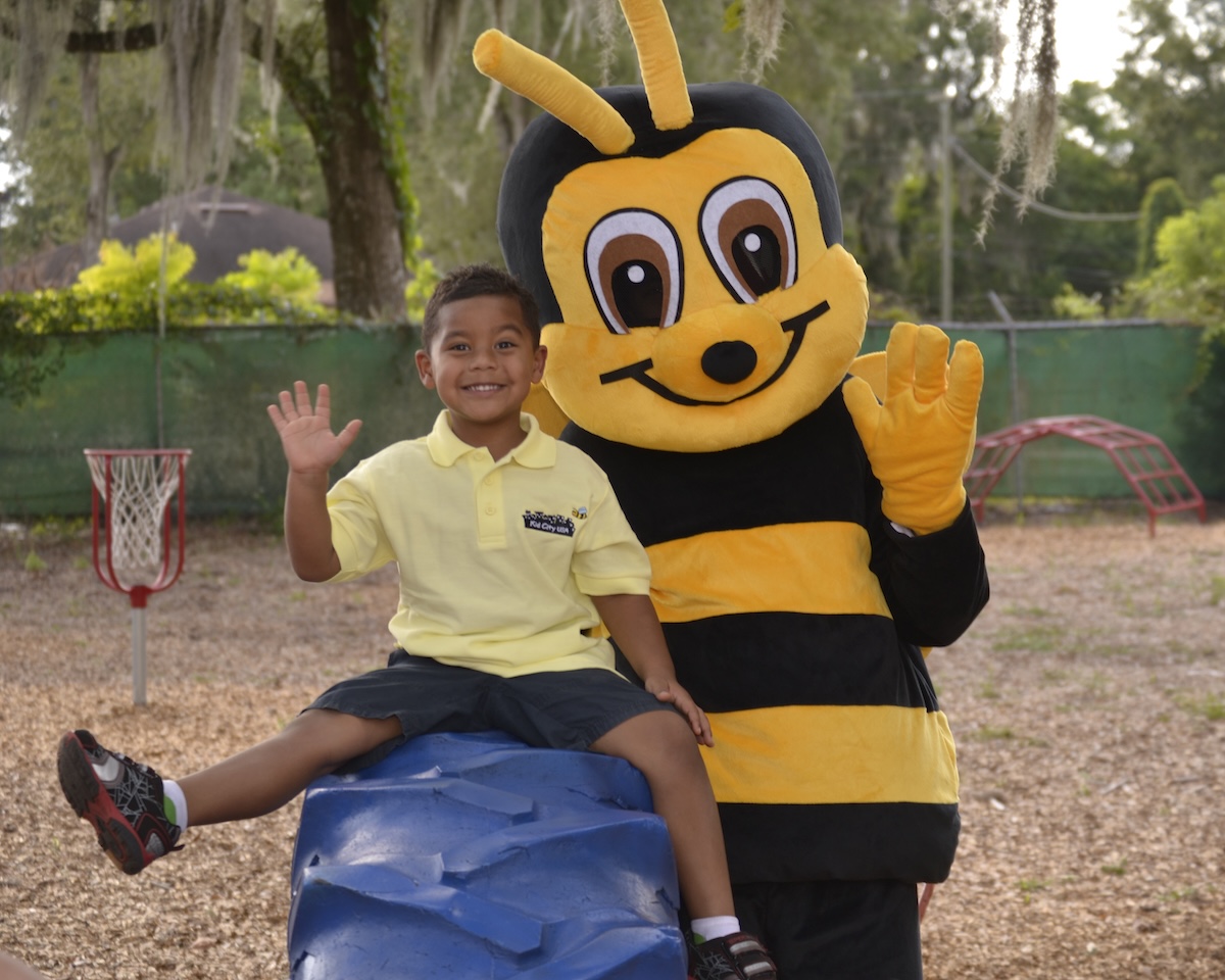 Kid City mascot with a child at the park