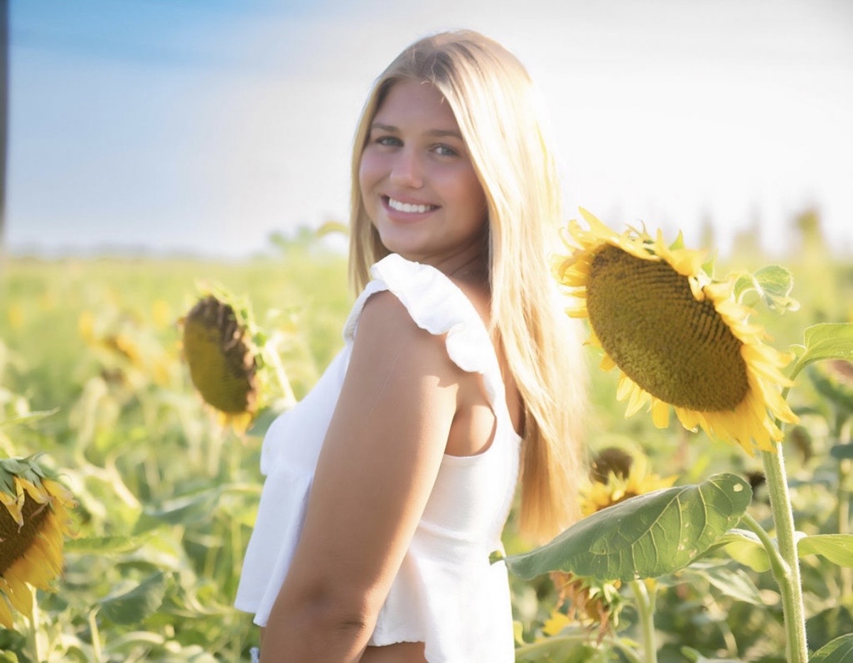 Taylor Freeman standing in a sunflower field