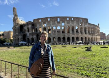 A woman standing in front of the Colosseum