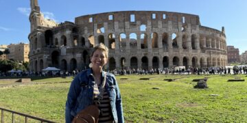 A woman standing in front of the Colosseum
