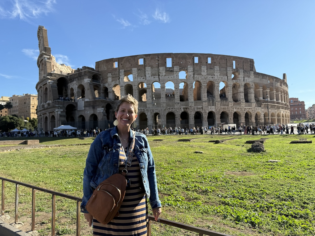 A woman standing in front of the Colosseum