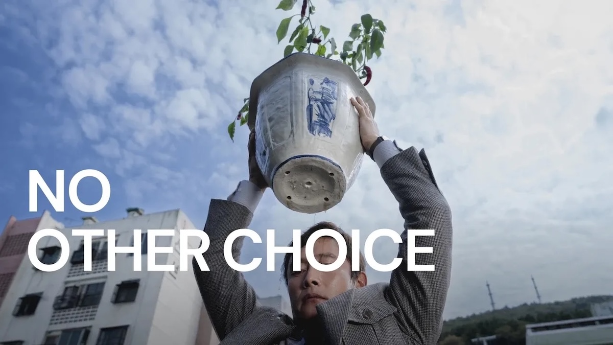 A man holding a plant above his head with the sky behind him.