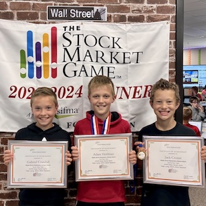 Three smiling Center Grove students holding their first-place certificates for the 2023-2024 Stock Market Game.