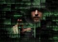 A hooded man's face is partially obscured by shadows and layers of glowing green computer code and symbols. The word "password" is highlighted in bright green near his hand, which is extended as if interacting with a digital interface. The dark, atmospheric image suggests themes of cybersecurity, hacking, or digital identity.