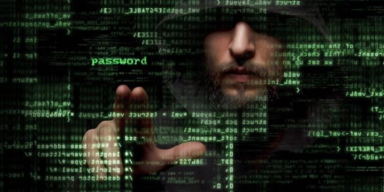 A hooded man's face is partially obscured by shadows and layers of glowing green computer code and symbols. The word "password" is highlighted in bright green near his hand, which is extended as if interacting with a digital interface. The dark, atmospheric image suggests themes of cybersecurity, hacking, or digital identity.