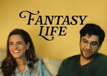 Amanda Peet (left) and Matthew Shear (right) sit on a couch in front of a yellow wall. Peet, with long brown hair and a denim shirt, laughs while looking off-camera. Shear wears glasses and a dark green shirt, looking down thoughtfully. The words "FANTASY LIFE" are printed in a stylized black font on the wall between them.