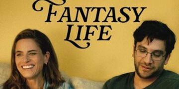 Amanda Peet (left) and Matthew Shear (right) sit on a couch in front of a yellow wall. Peet, with long brown hair and a denim shirt, laughs while looking off-camera. Shear wears glasses and a dark green shirt, looking down thoughtfully. The words "FANTASY LIFE" are printed in a stylized black font on the wall between them.