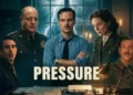 A promotional landscape image for the WWII movie Pressure. Five individuals stand in a dark, atmospheric room lit by candles and desk lamps. In the center stands Andrew Scott in a blue button-down shirt and tie with his arms crossed. To his left is Brendan Fraser in a decorated military uniform. Behind them, a large window reveals a dark night sky illuminated by brilliant, sharp streaks of lightning. In the foreground, a vintage typewriter and maps rest on a desk. The bold, white capitalized word "PRESSURE" is superimposed across the center of the image.