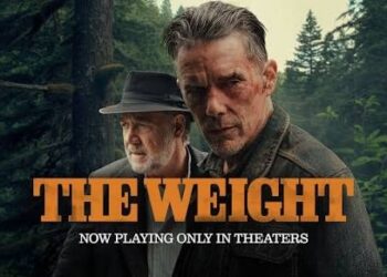 Poster for the movie "The Weight" showing Ethan Hawke and Russell Crowe. The foreground features a rugged, serious-looking Ethan Hawke with short, graying hair and dynamic facial features. Slightly behind him to the left stands Russell Crowe, wearing a dark fedora hat and a matching jacket over a button-up shirt, looking off to the side. They are positioned against a dense, dark green pine forest backdrop. The title "THE WEIGHT" is prominently displayed across the bottom in large, bold orange block letters, with the tagline "NOW PLAYING ONLY IN THEERS" written underneath in smaller white text.